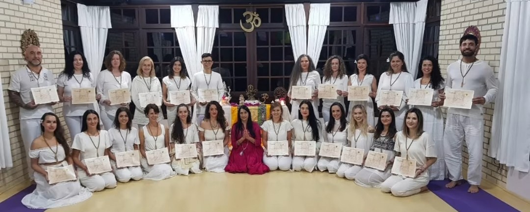 Formandos com certificados no salão do ashram, professora central de rosa