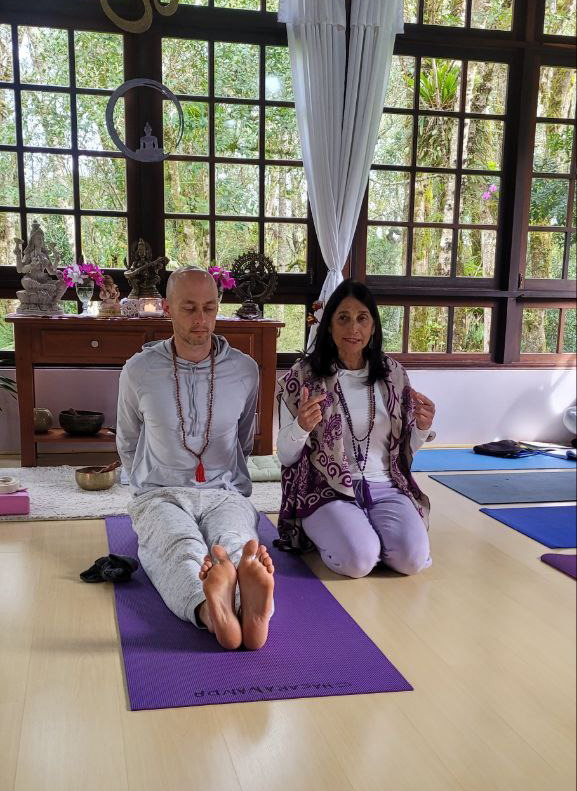 Instrutores conduzindo prática de Yogaterapia no salão do ashram
