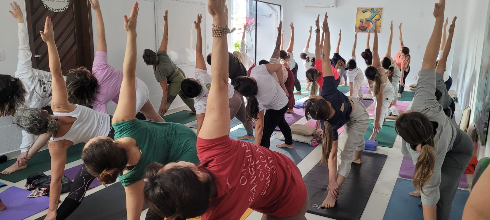 Alunos em aula prática de Yoga no salão do ashram