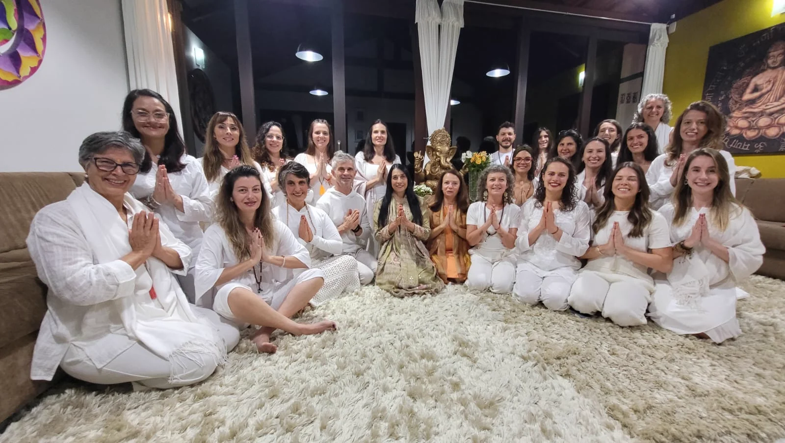 Formandos em Namaste no salão do ashram, com Ganesha ao fundo